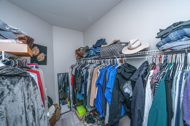 walk in closet with lofted ceiling and carpet