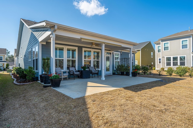 rear view of property with ceiling fan, a yard, and a patio area