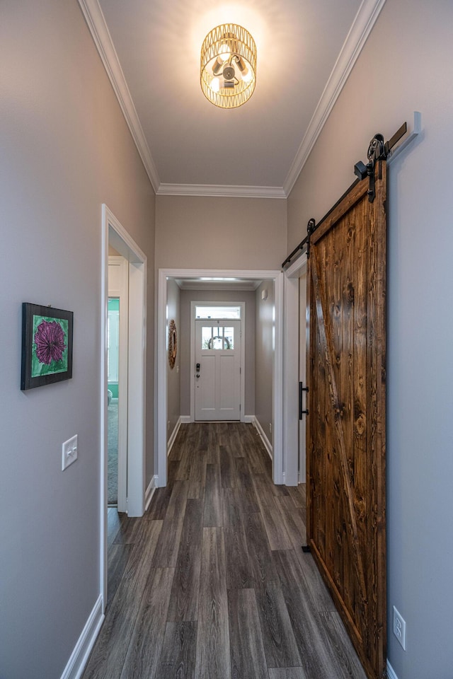 doorway to outside featuring a barn door, dark hardwood / wood-style floors, and crown molding