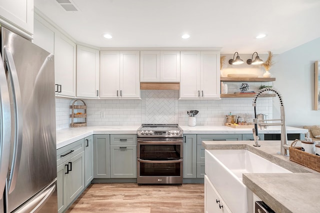 kitchen featuring white cabinetry, appliances with stainless steel finishes, sink, and light hardwood / wood-style flooring