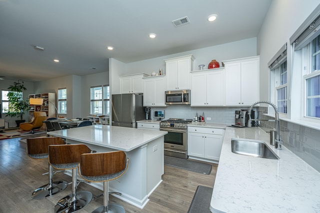 kitchen featuring sink, appliances with stainless steel finishes, a center island, and dark hardwood / wood-style flooring