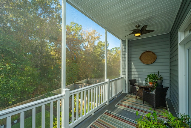 unfurnished sunroom with ceiling fan