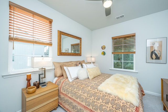 carpeted bedroom with multiple windows and ceiling fan