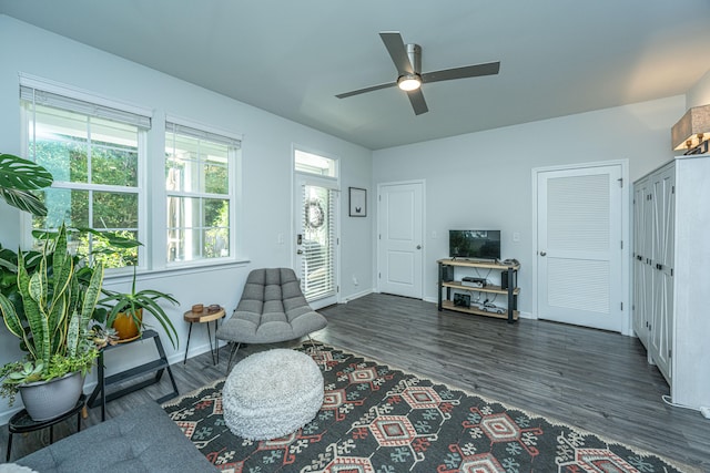 living room with dark wood-type flooring and ceiling fan