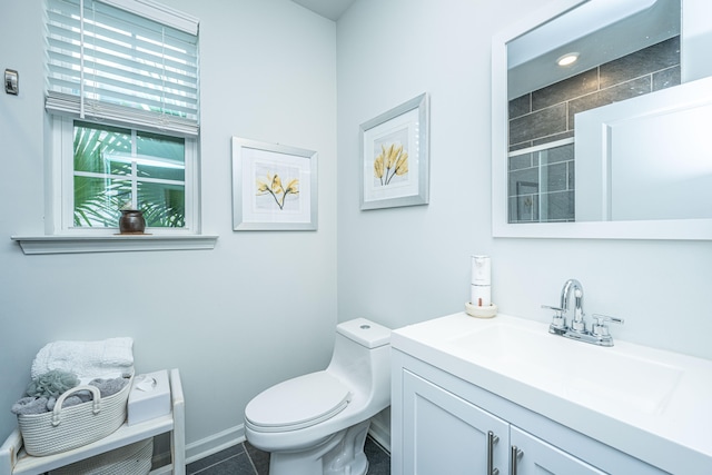 bathroom with toilet, vanity, and tile patterned flooring