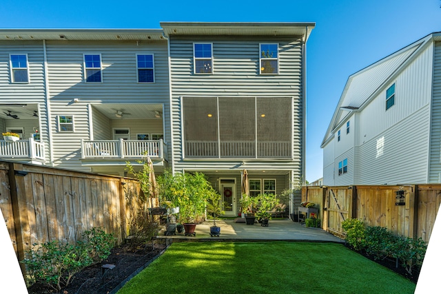 back of house with a balcony, a yard, and a patio