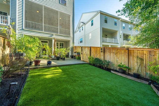 rear view of property featuring a patio area, a lawn, and a balcony