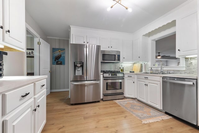 kitchen with light countertops, a sink, backsplash, and appliances with stainless steel finishes