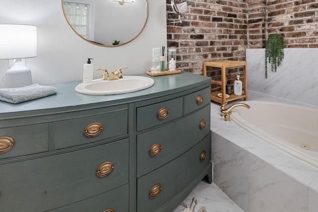 bathroom with marble finish floor, a garden tub, vanity, and brick wall