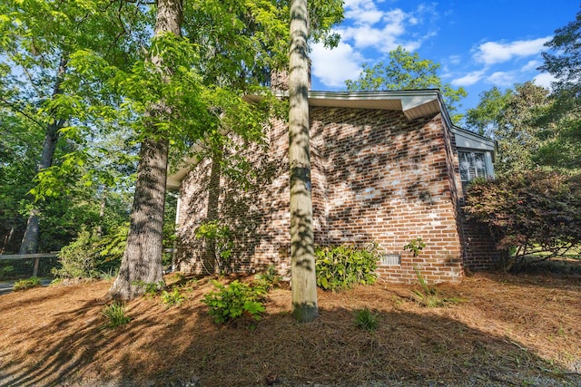 view of property exterior with crawl space and brick siding