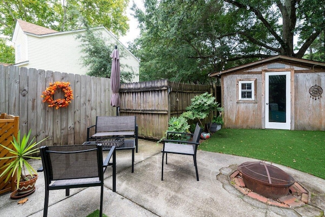 view of patio with an outdoor fire pit and a shed