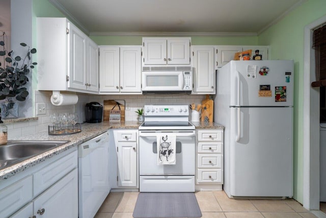 kitchen with white appliances, white cabinetry, tasteful backsplash, light tile patterned floors, and crown molding