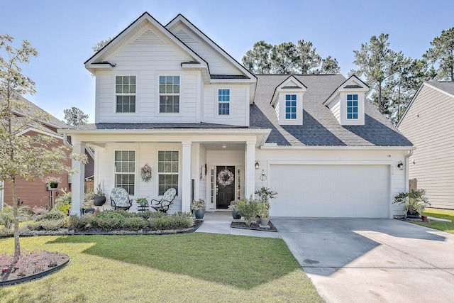 view of front facade featuring a porch, an attached garage, a shingled roof, driveway, and a front lawn