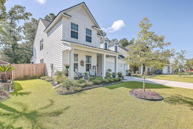 traditional-style home featuring concrete driveway, fence, and a front lawn