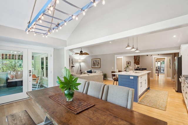 dining area featuring high vaulted ceiling, french doors, sink, ceiling fan, and light hardwood / wood-style floors