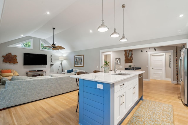 kitchen featuring sink, vaulted ceiling, ceiling fan, an island with sink, and white cabinetry