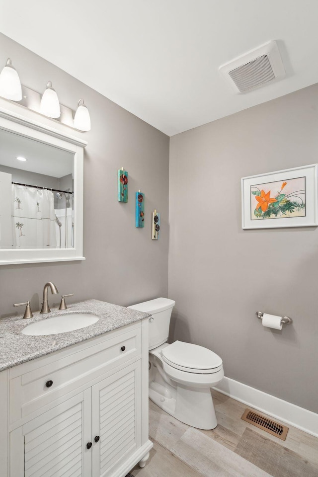 bathroom featuring hardwood / wood-style floors, vanity, and toilet