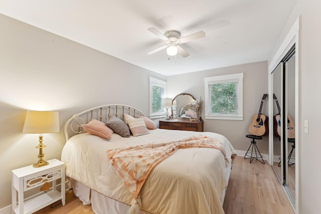 bedroom with a closet, light hardwood / wood-style floors, and ceiling fan