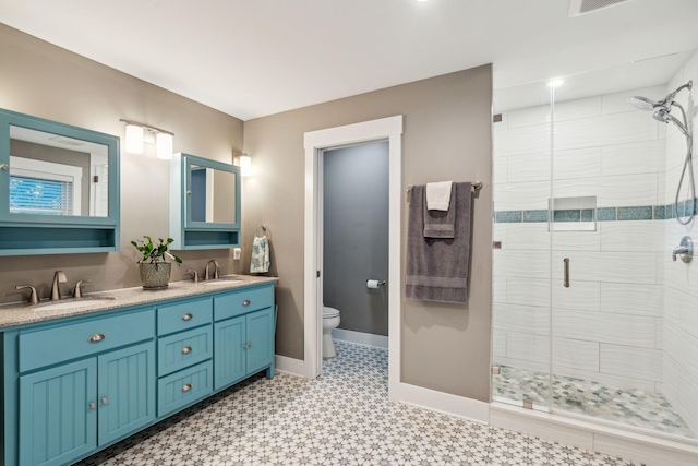 bathroom featuring vanity, toilet, and a shower with shower door