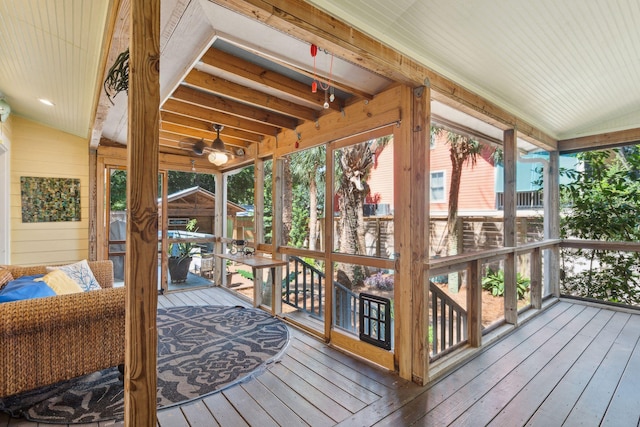 sunroom / solarium featuring vaulted ceiling and a healthy amount of sunlight