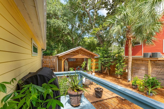 wooden deck with central AC and a storage shed