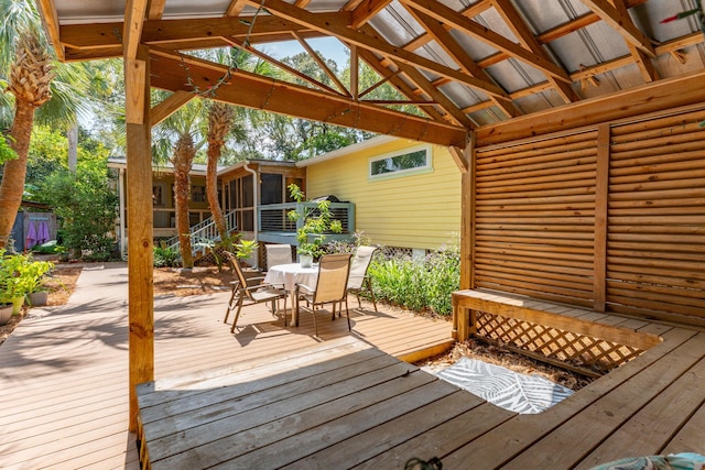 wooden deck featuring a gazebo and a sunroom