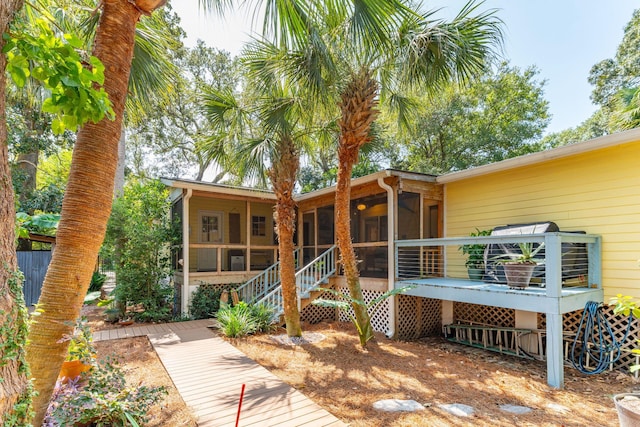 back of property with a deck and a sunroom