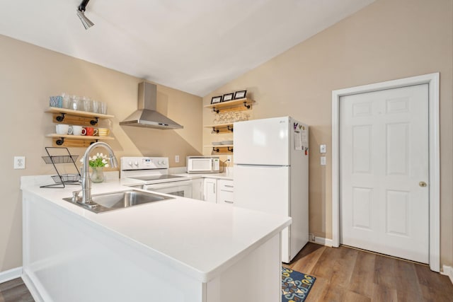 kitchen featuring sink, white appliances, wall chimney range hood, and kitchen peninsula