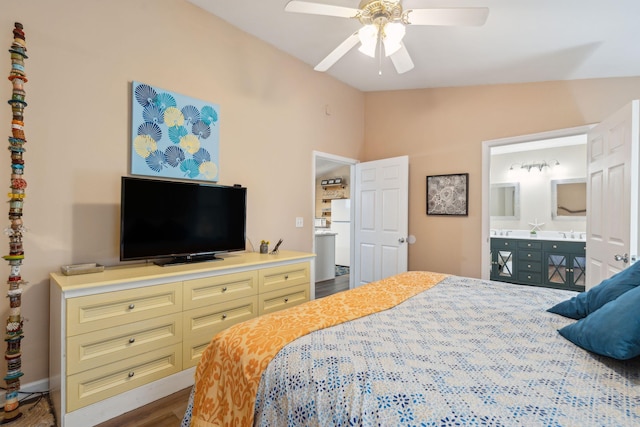 bedroom featuring ceiling fan, dark wood-type flooring, white refrigerator, ensuite bathroom, and vaulted ceiling