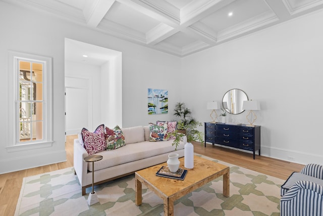 living room featuring light wood finished floors, ornamental molding, coffered ceiling, beamed ceiling, and baseboards