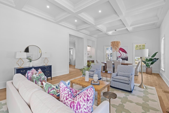 living area with beam ceiling, coffered ceiling, light wood-style flooring, and baseboards