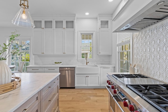 kitchen with glass insert cabinets, white cabinets, stainless steel appliances, and custom exhaust hood