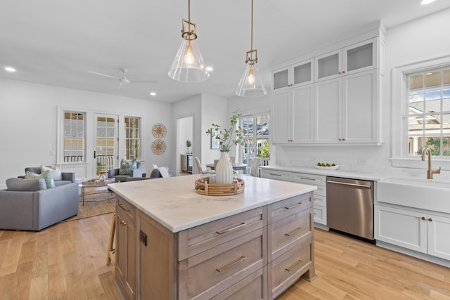 kitchen with open floor plan, white cabinets, and dishwasher