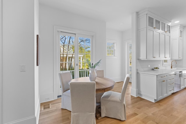 dining room with light wood finished floors, recessed lighting, visible vents, and baseboards