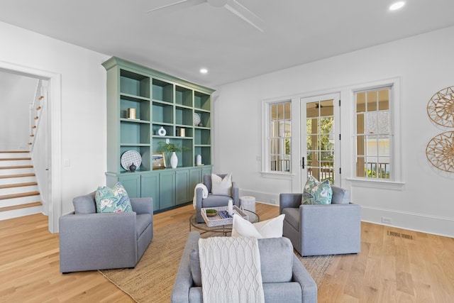 living area featuring light wood-type flooring, stairs, visible vents, and recessed lighting