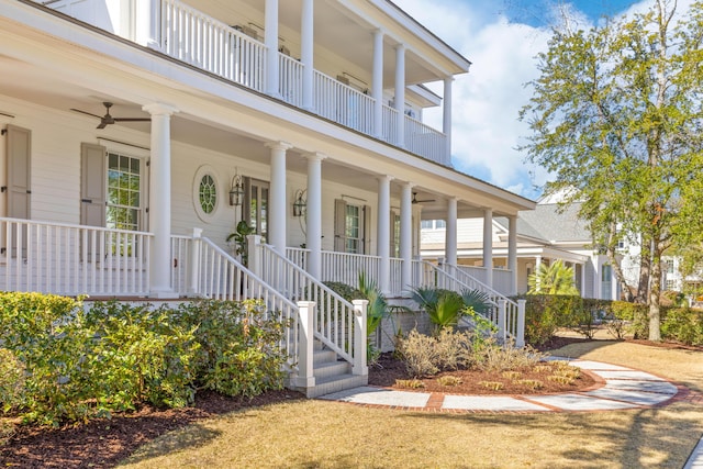 view of exterior entry featuring a balcony, covered porch, and a ceiling fan