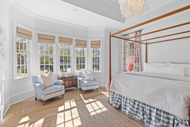 bedroom with crown molding, visible vents, an inviting chandelier, light wood-type flooring, and baseboards