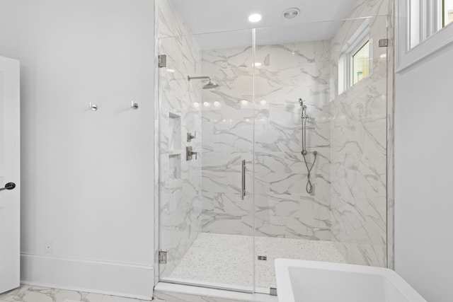 full bathroom with marble finish floor, a marble finish shower, and baseboards