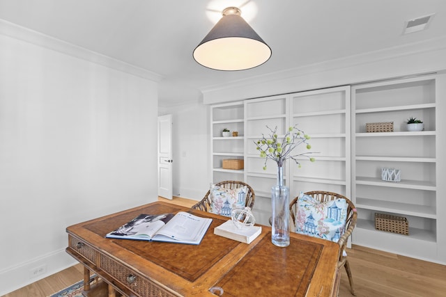 office featuring visible vents, crown molding, baseboards, and wood finished floors