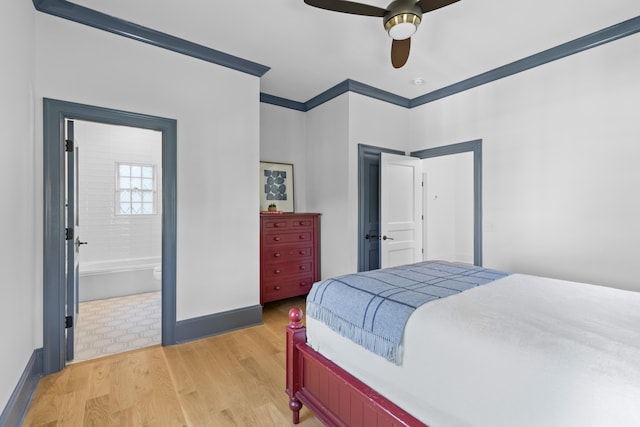 bedroom featuring light wood-style floors, ornamental molding, a ceiling fan, ensuite bath, and baseboards