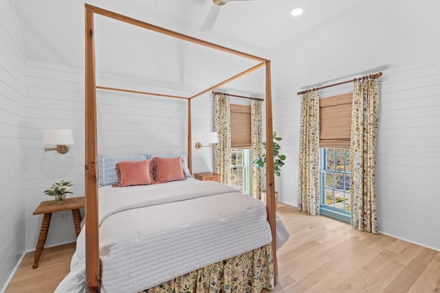 bedroom with wooden walls, recessed lighting, and light wood-style flooring