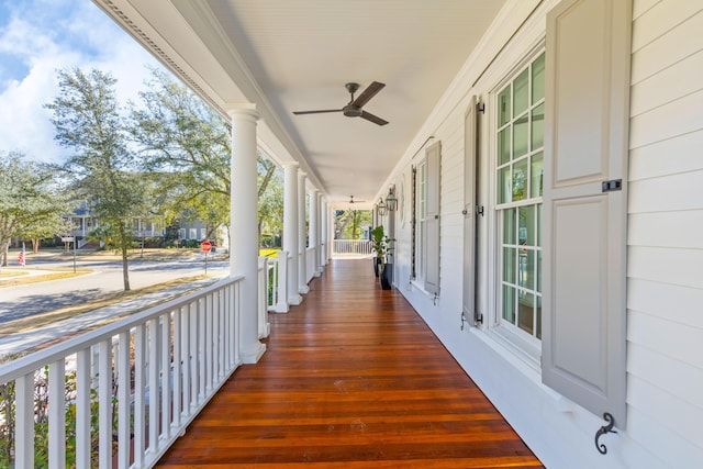 wooden terrace featuring covered porch and a ceiling fan