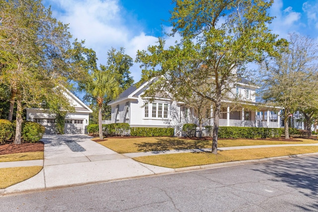 view of front facade with a garage, concrete driveway, and a front lawn