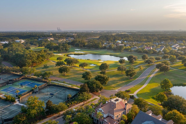 aerial view at dusk with a water view and a residential view