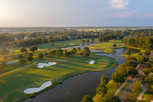 drone / aerial view with view of golf course and a water view