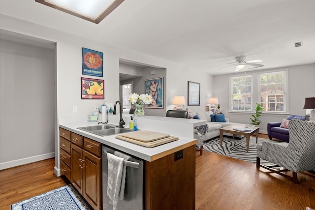 kitchen with ceiling fan, sink, hardwood / wood-style flooring, and stainless steel dishwasher