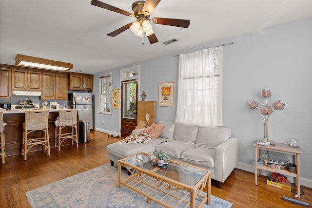 living room with hardwood / wood-style flooring and ceiling fan