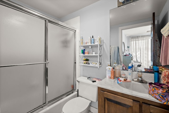 full bathroom with combined bath / shower with glass door, toilet, and large vanity