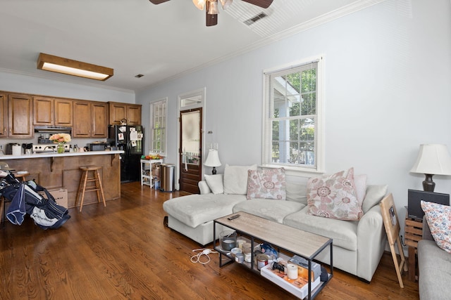 living room featuring dark hardwood / wood-style floors, ceiling fan, and crown molding