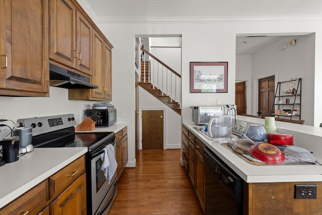 kitchen with black appliances, sink, ornamental molding, and wood-type flooring